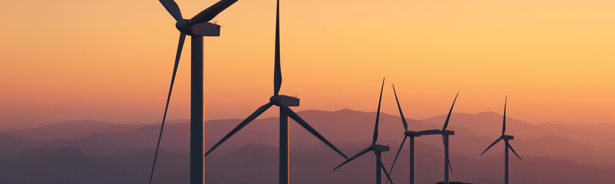Image of wind turbines on a hill during sunset
