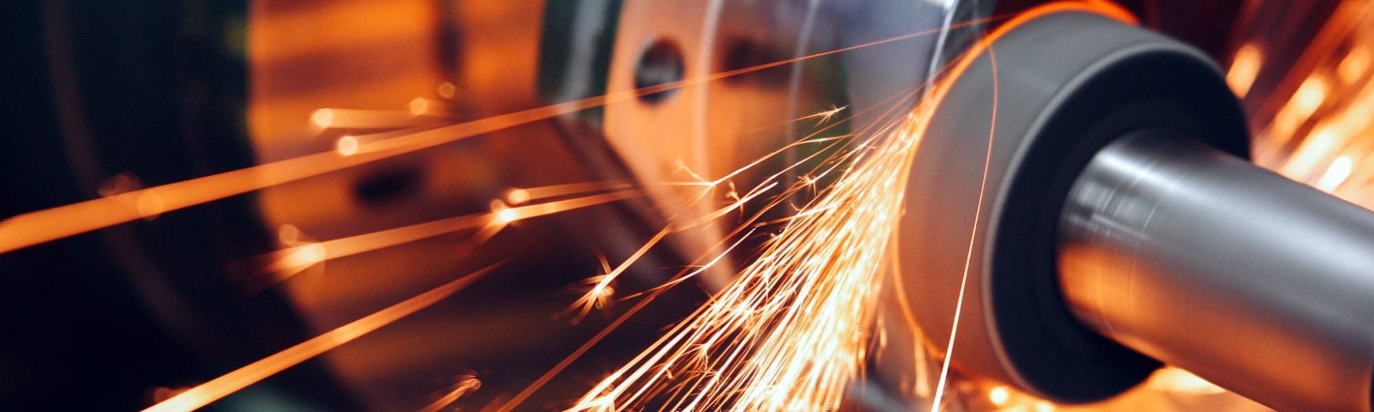 sparks flying while machine griding and finishing metal in factory, manufacturing, engineering